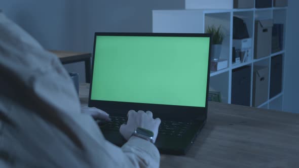 Closeup of a Laptop with a Green Screen in the Office in the Evening