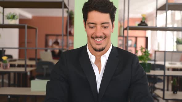 Confident Latin Businessman Using Laptop in the Office