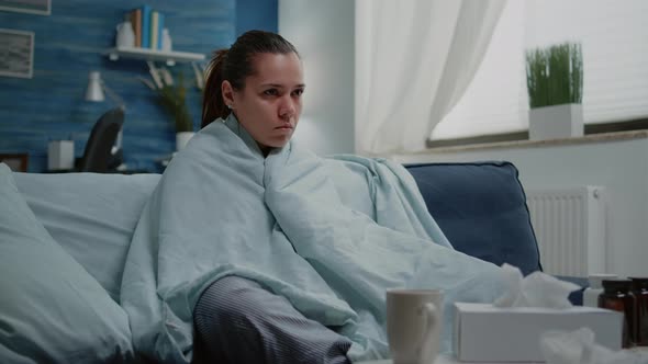 Sick Woman with Seasonal Flu Shivering in Blanket at Home