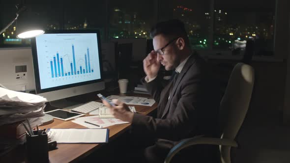 Businessman Analyzing Statistics at Night