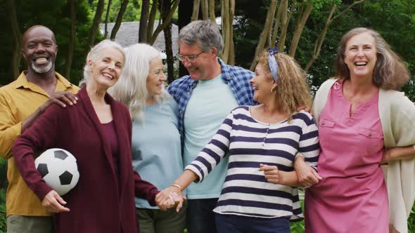 Animation of happy diverse female and male senior friends in garden, holding ball, posing to photo