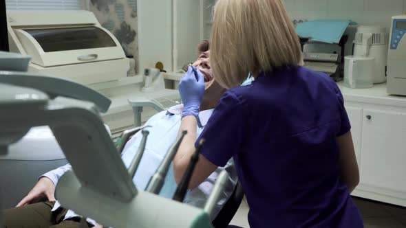 Stomatologist Performing Examination and Taking Care of the Teeth