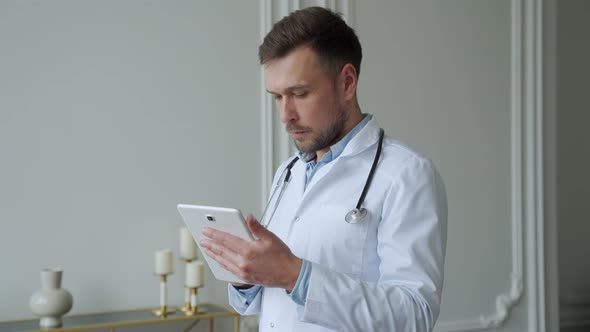 Man Doctor Using Tablet in the Consultation