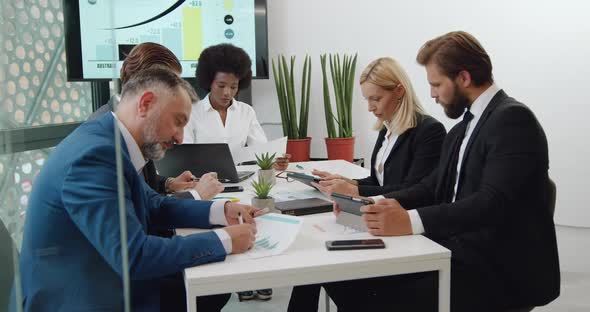 Workers which Sitting in Boardroom During Meeting with Blond Female Chief as to the Business Project