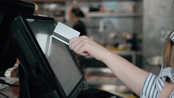 Side View of Young Bartender Using Modern Cash Register at Bar Counter