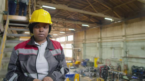 Female Worker Walking in Factory and Putting on Gloves