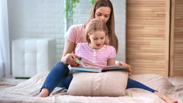 Adorable Woman and Cute Child Read Textbook Turning Paper Page