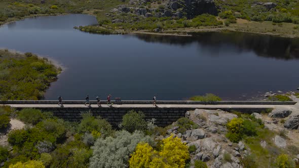 A crowd of tourists walk across a walkway on the edge of Covão dos Conchos.