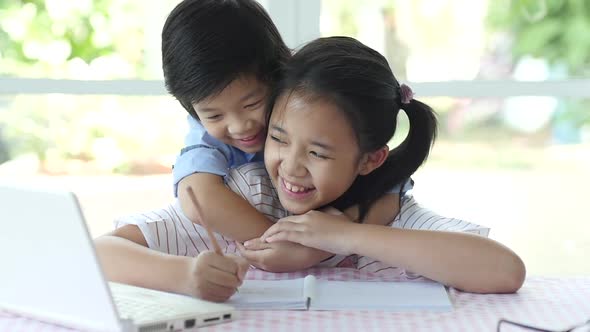 Asian Child Hugging His Sister From Behind