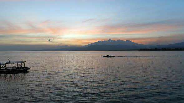 Fishing Boat in Calm Seas at Sunset with a Mountainous Background