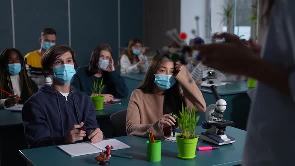 Masked Multiethnic Students Studying Chemistry