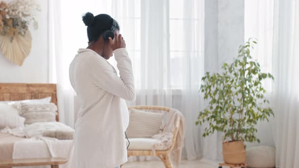 Happy African American Expectant Mother Pregnant Afro Black Ethnic Woman Dancing at Home Listening