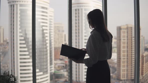 Silhouette of a Business Woman on the Background of Skyscrapers