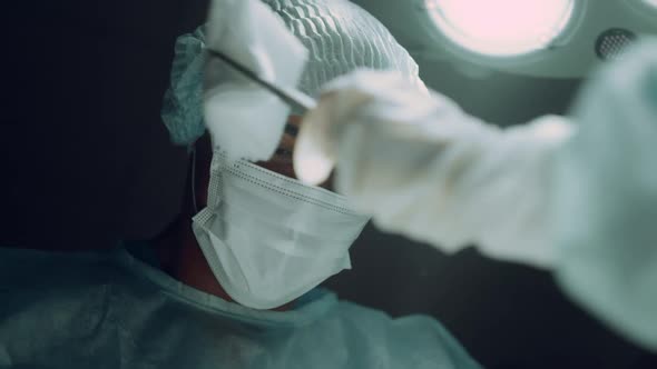 African American Surgeon Performing Hard Operation in Dark Clinic Ward Portrait