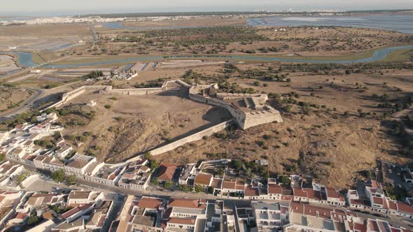 Panning aerial landscape of São Sebastião de Castro Marim fortress with vast expense of salt marsh.