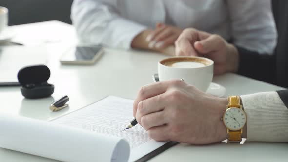 Closeup of a Table with a Laptop Two Cups of Coffee Female and Male Hands Without a Face