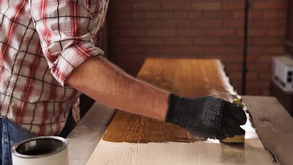 Woodworker Is Painting Wood By Brown Color in Small Craft Workshop