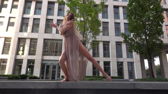 Beautiful Young Girl Dancing on the Street of a Modern Building of a Business Center. Slow Motion.