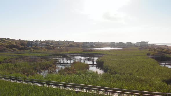 4k drone flight over dunes and piers in Oak Island NC