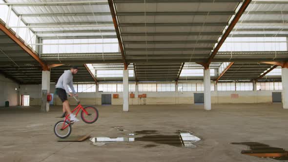BMX rider in an empty warehouse