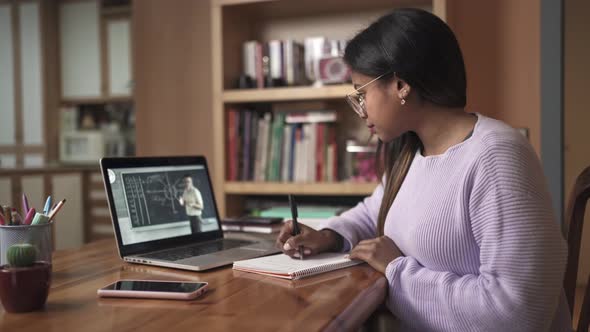 Young Female Black Student Watching Online Lesson with Math Teacher