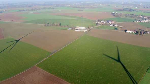 Aerial View of Wind Turbines on Agricultural Fields During Blue Winter Day