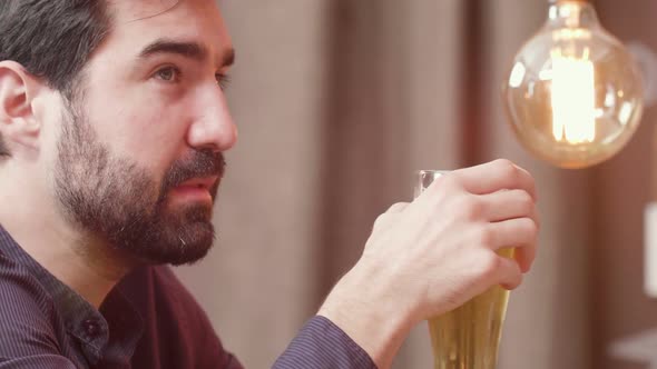 Handsome Bearded Man Drinks Beer and Talks To the Bartender