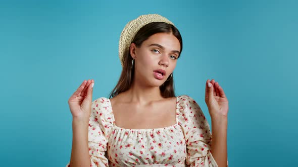 Cute Woman Showing Bla-bla-bla Gesture with Hands and Rolling Eyes Isolated on Blue Background