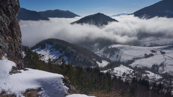 Low clouds holding in a snowy valley in winter frosty time, zoom in,timelapse video misty landscape