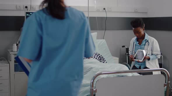 Practitioner Black Doctor Explaining Bones Radiography to Sick Man Using Tablet Computer