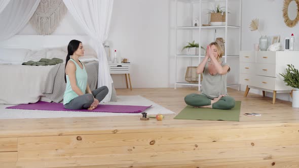 Yoga Instructor Showing Young Woman Breathing Exercise