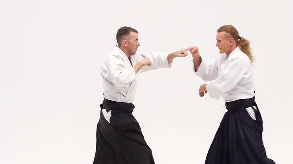 Two Guys in Kimono Demonstrating Aikido Techniques, Isolated on White. Close Up. Slow Motion.