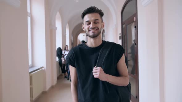 Handsome Young Man with Backpack Posing in University Hall