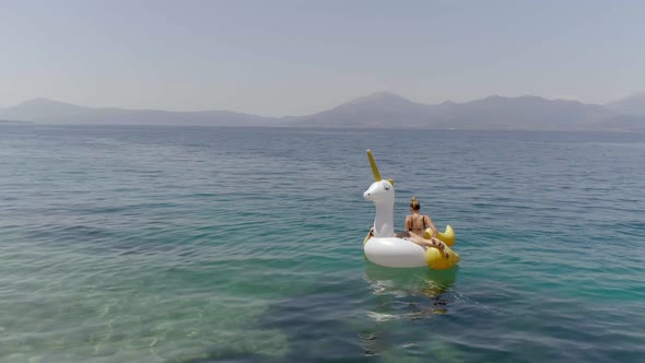 Aerial view of two women floating on inflatable in Panagopoula, Greece.