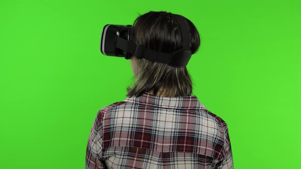 Young Girl Using VR App Helmet To Play Simulation Game. Woman Watching Virtual Reality 3d Video