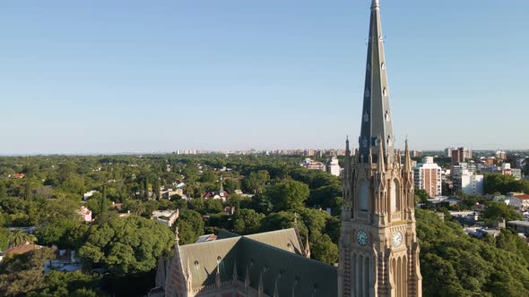 Aerial shot flying beside christian cathedral spire at golden hour