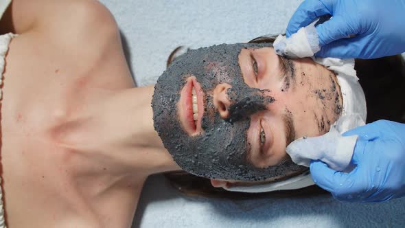 Cosmetologist Using Cotton Pads for Wiping the Mask