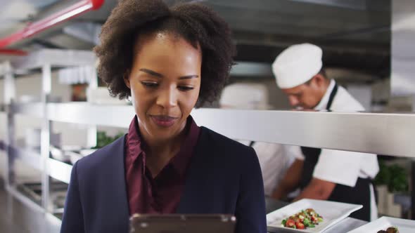 Portrait of african american female manager using tablet in restaurant kitchen