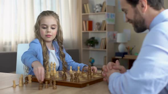 Little Blond Girl Playing Chess With Her Father at Home, Hobby and Relaxation