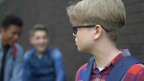 Violent Multiracial Schoolboys Laughing at Classmate in Eyeglasses, Humiliation