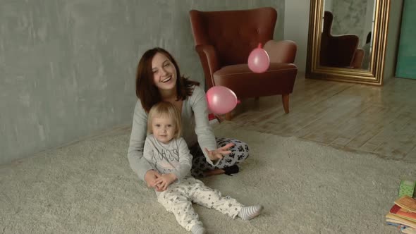 Mother and her little daughter plays with balloons