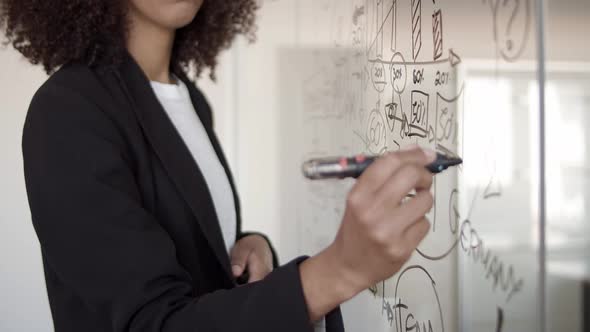 Young African American Manager Drawing Infographics with Marker