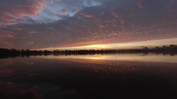 Colorful Yellowred Dawn Over the River with Clouds and Wind Timelapse