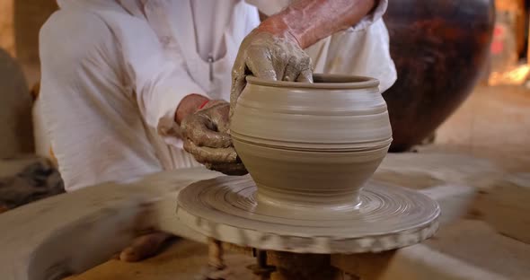 Skilled Hands of Potter Shaping the Clay on Potter Wheel and Sculpting Clay Pot Jar. Shilpagram