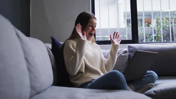 Woman having a video chat on her laptop at home