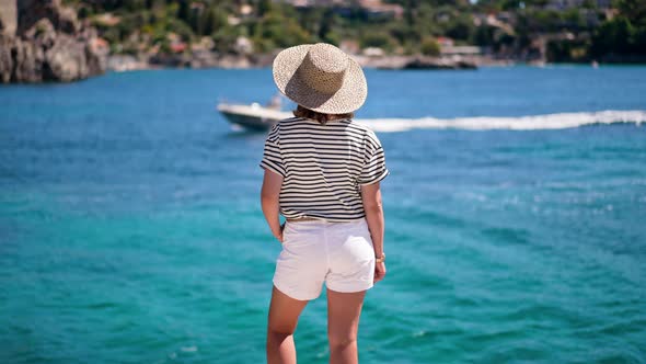 Woman in Striped Cruise Outfit is Watching on Motor Boat is Sailing Alongside