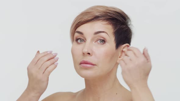 Close-up of middle aged mature woman over white background.