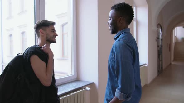 Two Uni Friends Standing in Hall, Talking