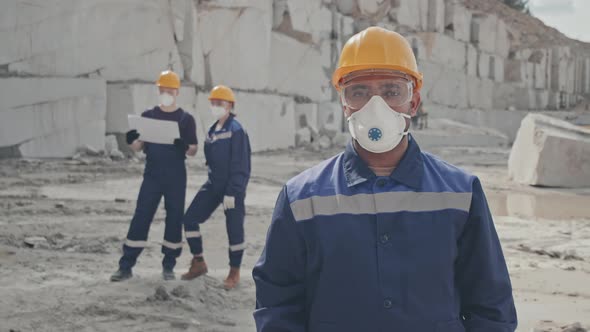 Worker in Dust Mask Posing in Granite Quarry