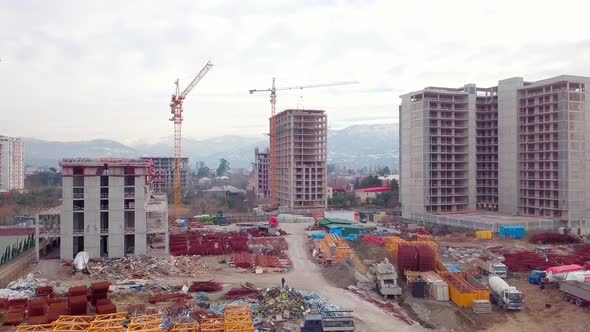Drone view of construction of multi-storey buildings background of mountains.